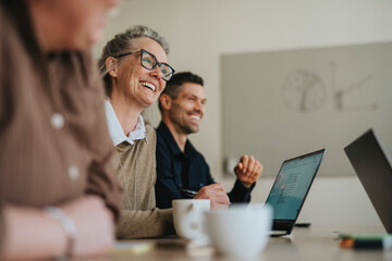 Happy female business professional with colleagues in meeting at office