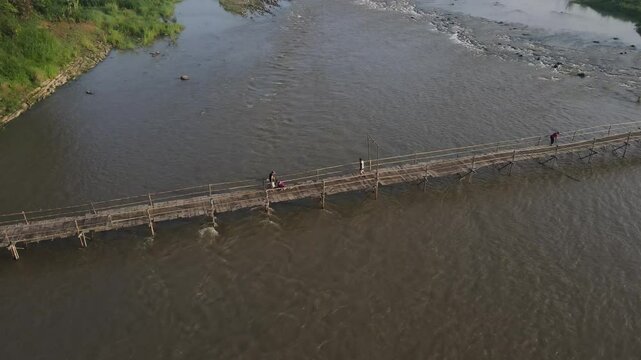 Aerial footage shows a wooden bridge spanning the Progo River, passable by motorbikes. As a link between the villages of Bantul and Kulonprogo.