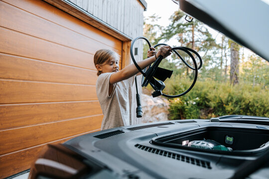 Boy putting charger in car storage compartment