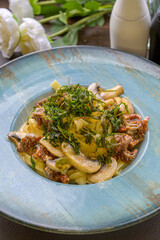 mediterranean pasta with mushrooms, sun-dried tomatoes, garlic and deep-fried rocket salad