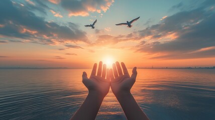 Hands raised in prayer, palms facing up, birds soaring above serene waters against a dusk sky. idea of pleading with God for blessings. 