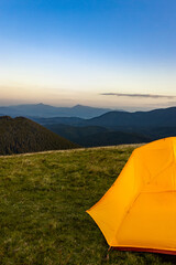 Sunset on the top of the mountain. A tent on the background of a mountain landscape. © Bondariev Volodymyr.