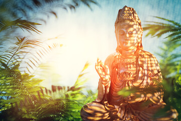 Buddha statue with dappled sunlight and shadows
