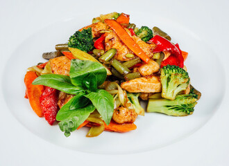 Colorful stir-fried vegetables with chicken meat on a white plate