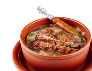 Steaming hot bowl of soup with meat and vegetables