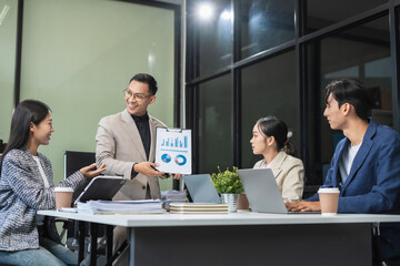 Group of Young Asian business team creative businesspeople coworker in office. Meeting Presentation for analysis graph company financial. People Work in Business Office.