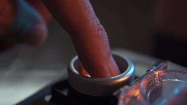 Pushing a red start button with cover