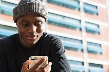 Concerned black man reading bad news on phone