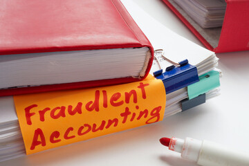 Stack of papers with a sticky note saying fraudulent accounting. Financial misconduct and business...