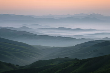 Obraz premium Breathtaking view of fog-covered mountains at dawn with a soft gradient sky in the background