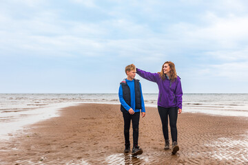 Brother and sister together at beach on a moody day