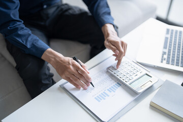 Man calculate finances home pay bills taxes on mobile phone and calculator financial at home