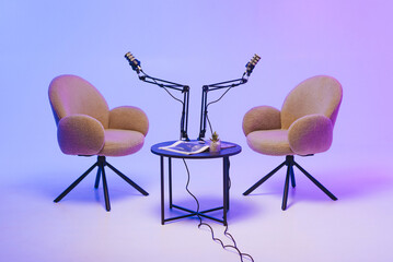 Two modern chairs with microphones set up for a podcast recording in a stylish studio at dusk
