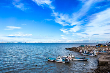 Yeongjongdo Island, Jung-gu, Incheon, South Korea - May 19, 2020: Fishing boats on the sea with Incheon Bridge in the background