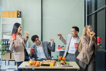Asian business team are excited business success with inspiration from their excellent financial results, celebration successful deal with champagne and pizza in the workplace.