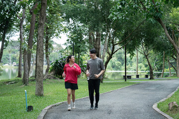 Obraz premium Young Couple Jogging in a Scenic Park for a Healthy Workout Routine