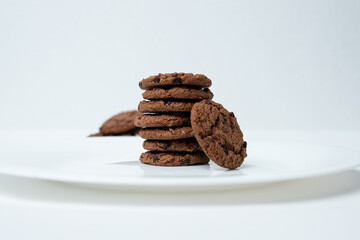 Chocolate chip cookies stacked on a white plate