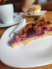 Piece of Plum Cake with Milk Coffee in Café Setting