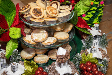 A plate of delicious tray of Christmas sweet mince fruit pies surrounded by Christmas decorations