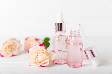 Rose essential oil on a textured background.Roses and a bottle of rose perfumed water.Aromatherapy treatment. Beauty concept. Spa procedure.Natural organic oil.Anti-stress,detox relax.Place for text
