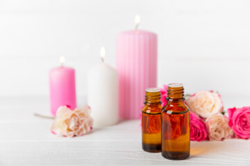 Rose essential oil on a textured background.Roses and a bottle of rose perfumed water.Aromatherapy treatment. Beauty concept. Spa procedure.Natural organic oil.Anti-stress,detox relax.Place for text