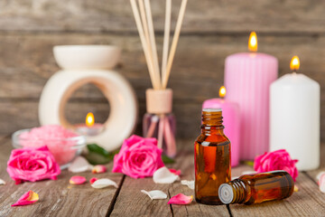 Rose essential oil on a textured background.Roses and a bottle of rose perfumed water.Aromatherapy treatment. Beauty concept. Spa procedure.Natural organic oil.Anti-stress,detox relax.Place for text