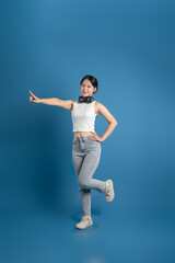 Obraz premium Portrait of beautiful Asian woman posing on blue background.