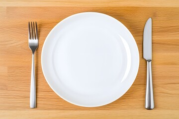 A simple white plate on a minimalist wooden table, with a knife and fork neatly placed beside it