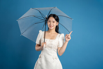 Portrait of beautiful Asian woman posing on blue background.