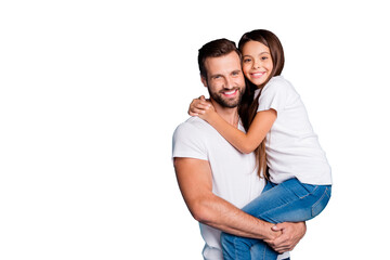 Portrait of lovely man with brunet hair cut holding his daughter having long hair wearing white casual t-shirt denim jeans isolated over blue background