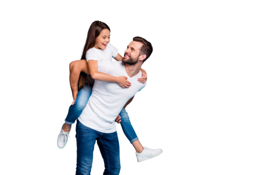 Portrait of cheerful man holding his kid with brunette hairstyle piggyback wearing white t-shirt denim jeans isolated over blue background