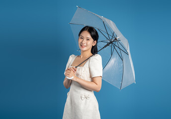Portrait of beautiful Asian woman posing on blue background.