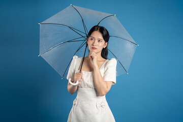 Portrait of beautiful Asian woman posing on blue background.