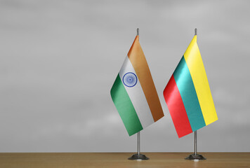 Table flags of Lithuania and India on grey blurred background