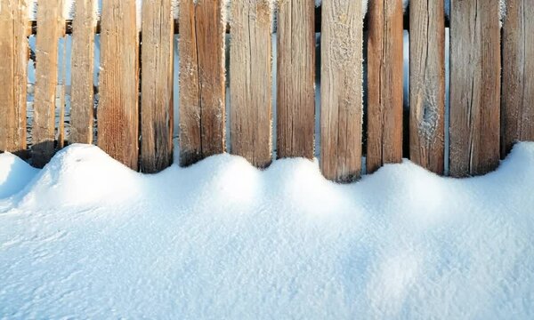 Snow-covered wooden fence, with the rough texture of the wood partially hidden under a smooth layer of snow. . Video