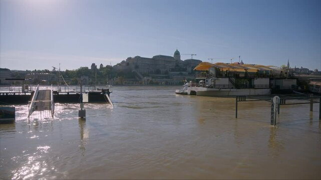Rakpart in Budapest flooded by the Danube after excessive heavy rains in Central Europe. Floodwaters are covering roads in Hungary. View of Buda Castle during the flood. Water covering the roads.