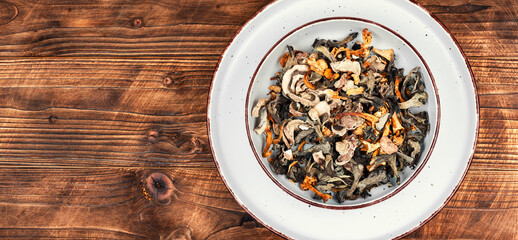 Dried mushrooms on rustic wooden table.