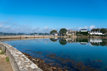 Obraz premium Peaceful coastal houses reflected in water on Île de Saint-Cado