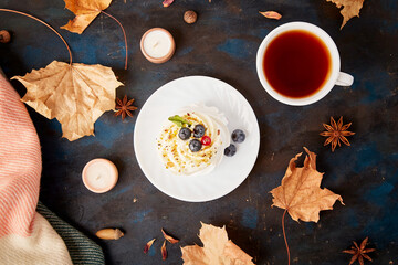 Traditional Delight Pavlova Dessert with Tea Cup. Autumn tea time vibes background. Hygge...