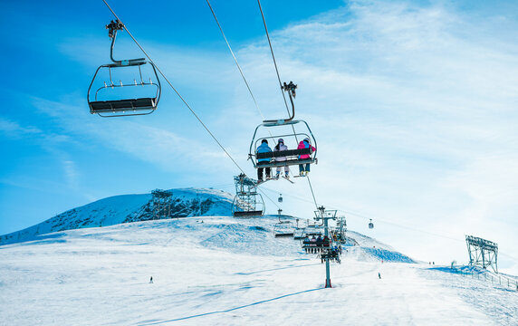 People on ski lift in winter sport resort - Travel and vacation concept - Focus on three people body