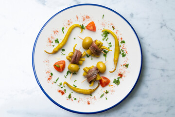 Gilda. Basque tapas pincho with chilli, anchovy and olive. Top view table with  decorations.