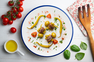 Gilda. Basque tapas pincho with chilli, anchovy and olive. Top view table with  decorations.