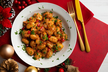 Delicious Italian gnocchi with pesto rosso. Top view table with christmas decorations.