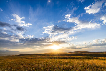 Obraz premium Yellow grassland and beautiful sky clouds nature landscape at sunset. Autumn landscape.
