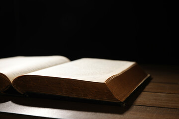 Open Bible on wooden table, closeup. Christian faith