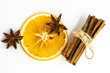 Cut orange and different spices  on white background. Traditional festive winter beverage.Cinnamon, dried orange, anise and cloves