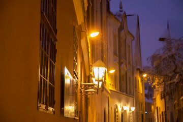 Fototapeta premium Lantern with yellow warm light. Street lights, illumination in the Old Riga, Latvia.