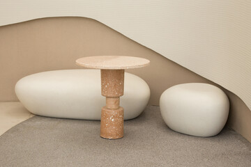 A minimalist interior featuring uniquely textured furniture in neutral tones creates a serene...