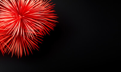 Brilliant red firework explosion against dark night sky. Vibrant pyrotechnic display with radial light trails. Festive celebration imagery with copy space for holiday or event themes.