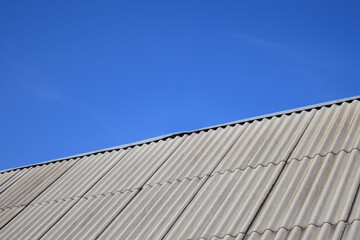 Fototapeta premium New asbestos roof with clean lines under a bright blue sky